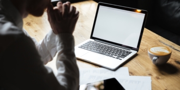 Cropped photo of businessman sitting at wooden table, focus on l